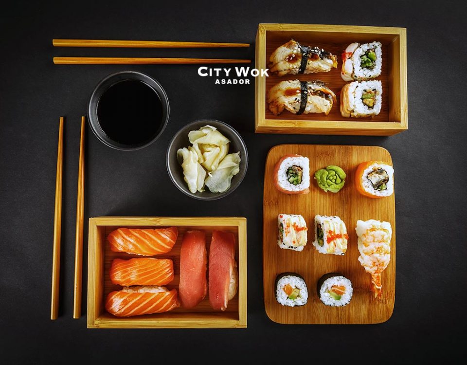 El origen del sushi, es verdad que es muy típico de la comida japonesa. Al igual que es muy popular en el extranjero. Por esto, te vamos a contar las diferentes variedades de sushi. La isla de Japón está rodeada de aguas muy ricas en plancton. Esto genera que tengan una gran variedad de pescados y mariscos. Contribuyendo a la excelencia de las diferentes variedades de sushi. Pero, por si no sabias originariamente, el sushi no es de Japón. Según datos históricos, las diferentes variedades de sushi comenzaron en el siglo II d.C. precisamente en China. Utilizaban un método de conservación. Al empezar cocían el arroz, mientras que el pescado se dejaba fermentar por un tiempo. Al principio sólo se comía el pescado. La palabra Sushi es de origen japonés y es la unión de dos palabras. Su significa vinagre y Shi-Meshi, Arroz. Es por ello que sushi se traduce como Arroz Avinagrado. Veamos su historia y las diferentes variedades de sushi que existen. Historia El tipo de arroz que se utiliza para las diferentes variedades de sushi se llama koshihikari. Tiene por característica ser un grano redondo, corto, dulce y con un alto contenido de almidón. Para trabajar correctamente este arroz, primero tenemos que quitarle el almidón, llevándolo de siete a ocho veces, hasta que el agua salga transparente. Luego iremos creando las diferentes variedades de sushi. Dentro del origen del sushi, sobre el siglo IV a.C. en el sureste asiático. La comida era conservada. El pescado se almacenaba en sal y se fermentaba el arroz. Una vez limpio el pescado, se metía en arroz para que la fermentación natural ayudara a la conservación del mismo. Esta clase de sushi se llama narezushi y entonces solo se comía el pescado y se tiraba el arroz. Con el transcurso del tiempo, sobre el siglo VIII d.C. esta forma de conservar las diferentes variedades de sushi llegó a Japón. Pero como los japoneses preferían comer arroz con pescado, comenzaron a consumirlo mientras el pescado estaba aún medio crudo y el arroz no había perdido su sabor. Y denominaron a este tipo de sushi seiseizushi. Que se convirtió en una forma de cocinar en vez de un método de conservación de los alimentos. A mediados del siglo XVII, el doctor Matsumoto Yoshichi, agregó a las diferentes variedades de sushi la opción de añadir vinagre al arroz. Esto hizo que se redujera notablemente el tiempo de espera para consumir el sushi. Pasando el tiempo nació el Hayazushi, donde en vez de fermentado, el arroz se mezclaba con vinagre y se consumía junto con el pescado, verdura o alimentos en conserva. Por entonces, a partir del siglo XIX, Hanaya Yohei inventó el nigirizushi una de las diferentes variedades de sushi. Es el tipo de sushi que no precisa fermentación además de poder comerse con las manos. Las diferentes variedades de sushi llevaron a convirtirlo en comida rápida, ligera y nutritiva. Ahora bien ¿sabrías diferenciar las diferentes variedades de sushi? Variedades del sushi en Asador City Wok Guipúzcoa Maki La palabra maki significa “rollo”. Por lo tanto es un rollo de alga nori relleno de arroz y distintos ingredientes como pescado, marisco, frutas o verduras. Son muy populares y permiten poner mucha imaginación a sus rellenos. Nigiri El nigiri está compuesto por una bola de arroz. La misma se moldea con la mano y por encima se aplica un trozo de pescado crudo. La loncha debe estar finamente fileteada. También pueden usarse ingredientes como pulpo cocido, anguila o tortilla. La diferencia que trae el nigiri con el resto de tipos de sushi como el maki o el temaki, es que no va envuelto en alga nori. Sashimi El sashimi es una forma de preparar el pescado o el marisco. Consiste principalmente en cortarlo en lonchas de un grosor determinado para poder consumirlo tal cual, crudo. Más específicamente sin cocción alguna. Tal y como salió del mar. Dependiendo del tipo de pescado o marisco el resultado puede variar. Ya que hay diferentes tipos de corte y esto origina diferentes variedades de sashimi. ¡Si quieres degustar sushi fresco visita nuestro Asador City Wok Guipúzcoa!